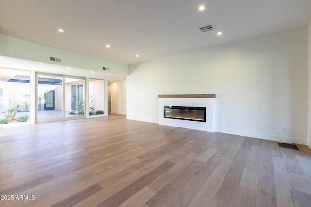 unfurnished living room with floor to ceiling windows and light hardwood / wood-style flooring