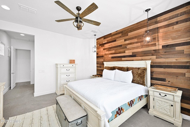 bedroom with a ceiling fan, baseboards, visible vents, carpet floors, and wood walls