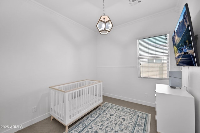 carpeted bedroom with visible vents, baseboards, a nursery area, and crown molding