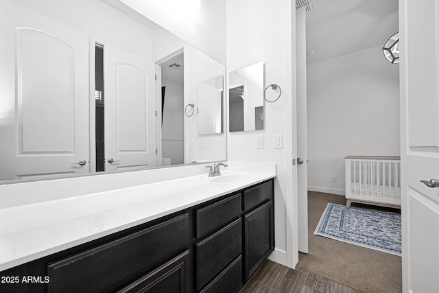 bathroom with vanity, baseboards, and wood finished floors