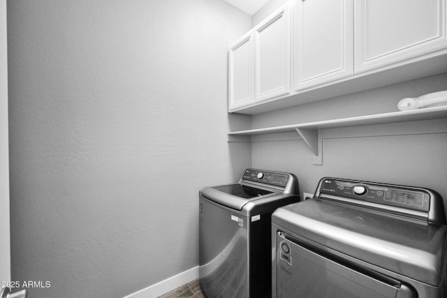 clothes washing area with cabinet space, washer and dryer, baseboards, and wood finished floors