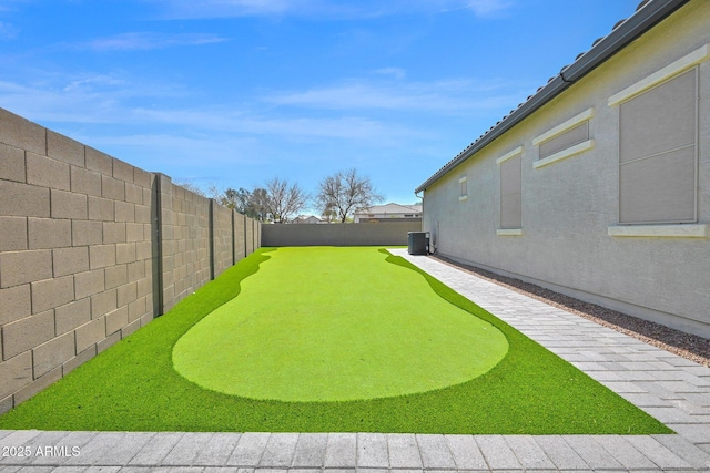 view of yard featuring a fenced backyard and central AC