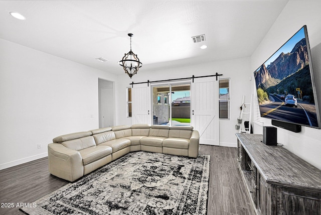 living room featuring visible vents, dark wood-style floors, recessed lighting, a barn door, and baseboards