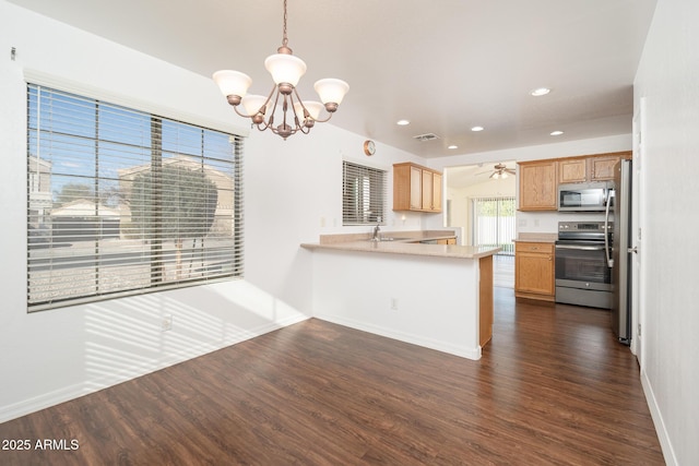 kitchen featuring dark wood-style floors, a peninsula, stainless steel appliances, and light countertops