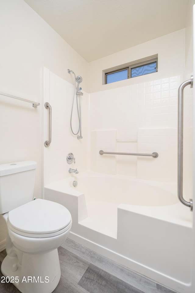 full bath featuring toilet, wood finished floors, and shower / bathtub combination