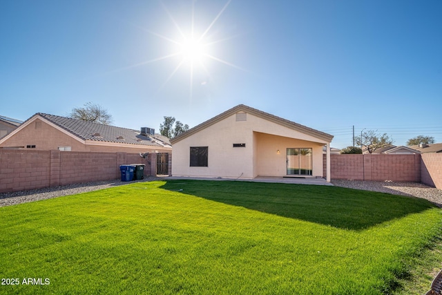 rear view of property featuring stucco siding, a patio, a yard, and a fenced backyard