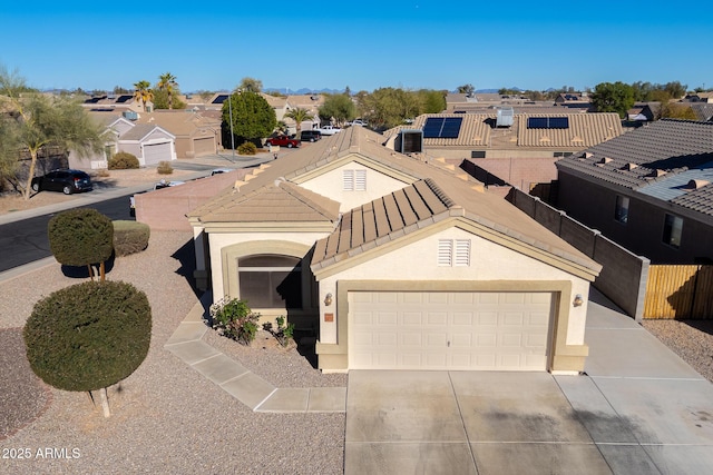 view of front of property featuring driveway, an attached garage, stucco siding, a tiled roof, and a residential view