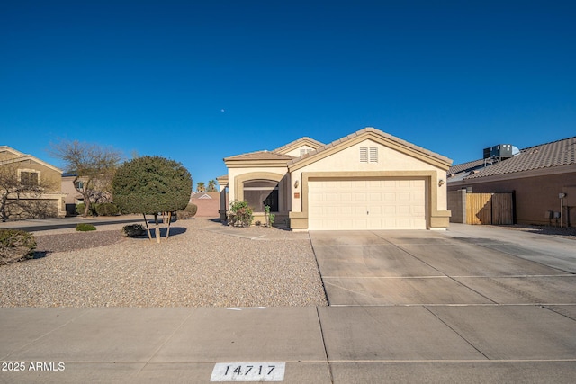 view of front of home featuring fence, an attached garage, stucco siding, concrete driveway, and a tile roof