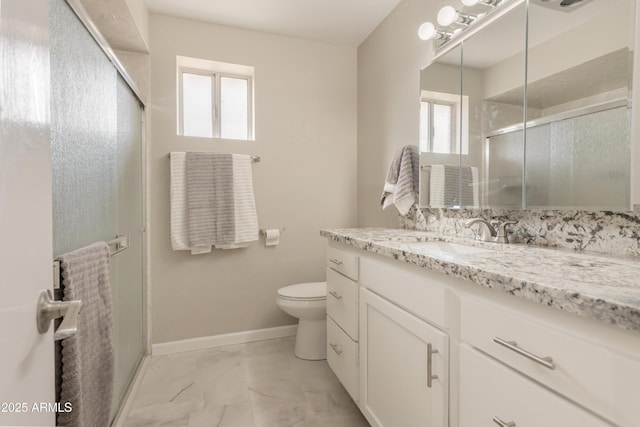 bathroom with vanity, a shower with shower door, and a wealth of natural light