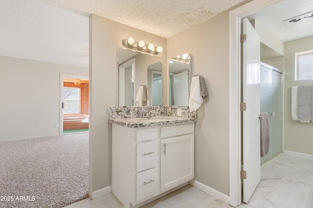 bathroom featuring vanity, an enclosed shower, and a textured ceiling