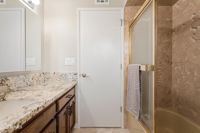 bathroom featuring vanity and combined bath / shower with glass door