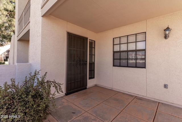 property entrance with a patio area and stucco siding