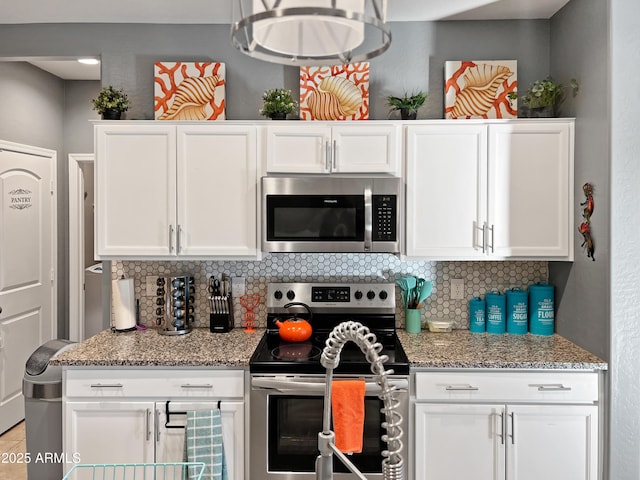 kitchen featuring light stone countertops, appliances with stainless steel finishes, tasteful backsplash, and white cabinetry