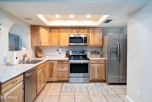1531 S Padre Rd, Apache Junction, AZ 85119 - kitchen featuring appliances with stainless steel finishes, a tray ceiling, a sink, light brown cabinetry, and recessed lighting
