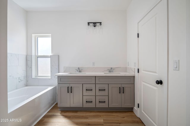 bathroom with vanity, hardwood / wood-style flooring, and a bathing tub