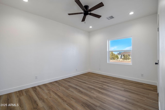 spare room with hardwood / wood-style floors and ceiling fan