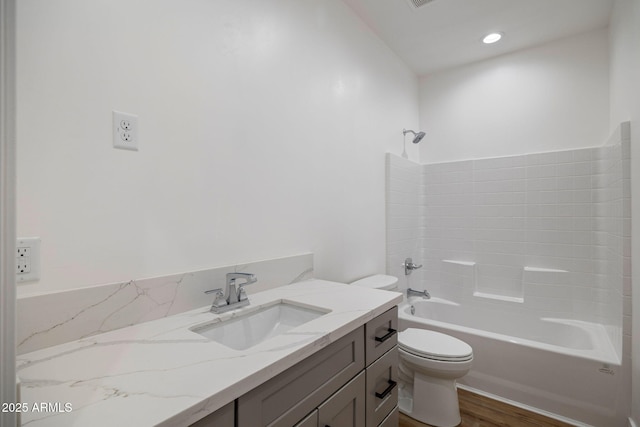 full bathroom featuring vanity, tub / shower combination, hardwood / wood-style floors, and toilet