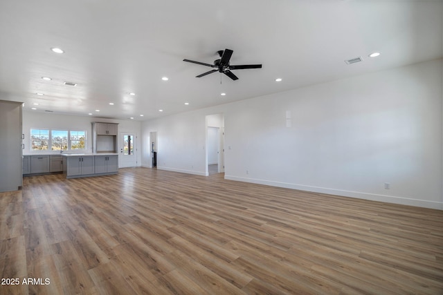 unfurnished living room with ceiling fan and light wood-type flooring