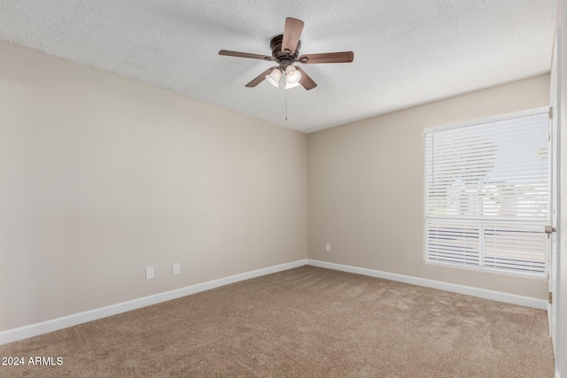 carpeted spare room featuring ceiling fan and a textured ceiling