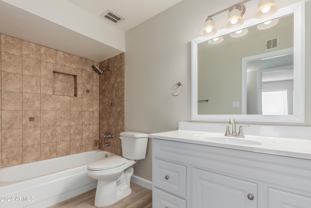 full bathroom featuring hardwood / wood-style flooring, vanity, toilet, and tiled shower / bath