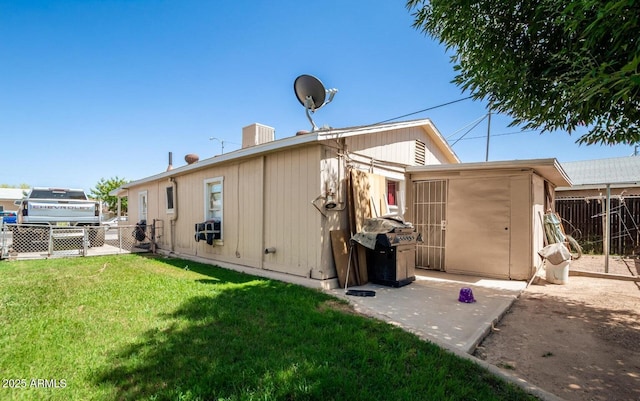 back of property featuring a yard and fence