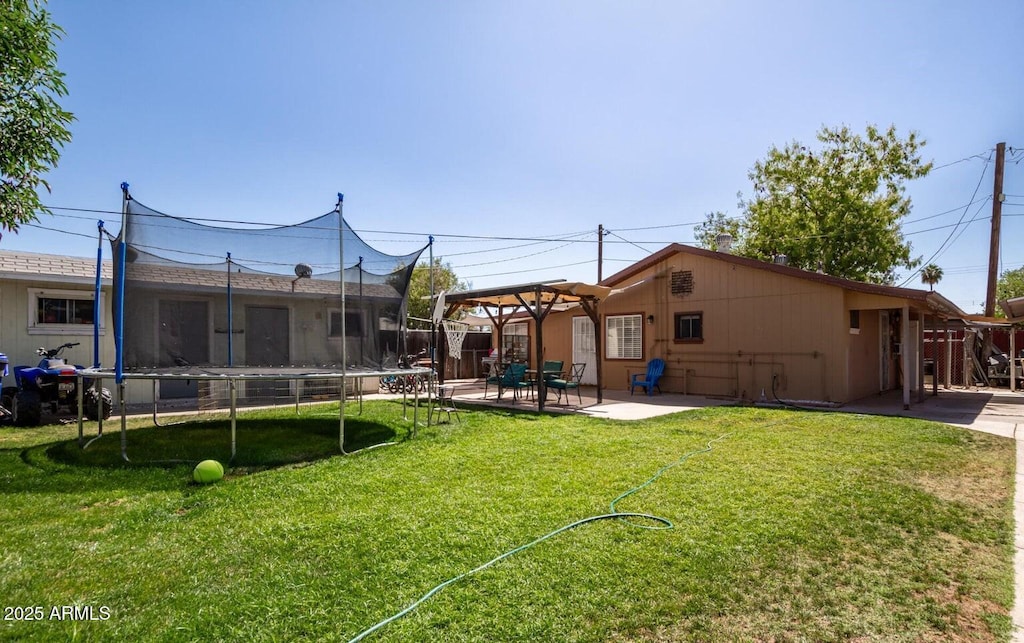 view of yard featuring a patio and a trampoline