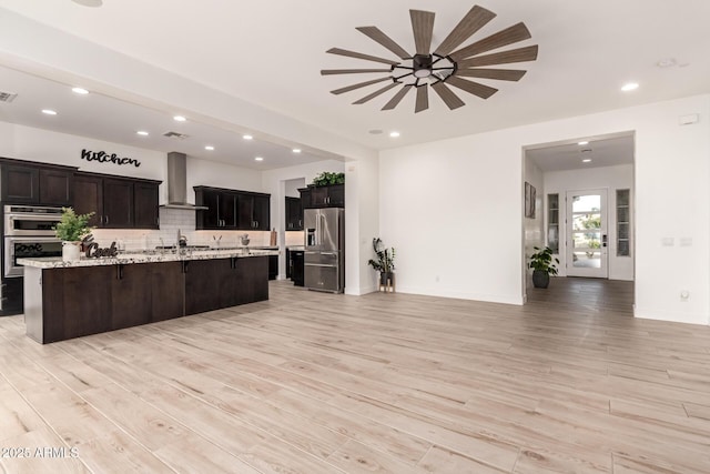 2316 E Canary Dr, Gilbert, AZ 85297 - kitchen featuring wall chimney exhaust hood, appliances with stainless steel finishes, ceiling fan, open floor plan, and a kitchen breakfast bar