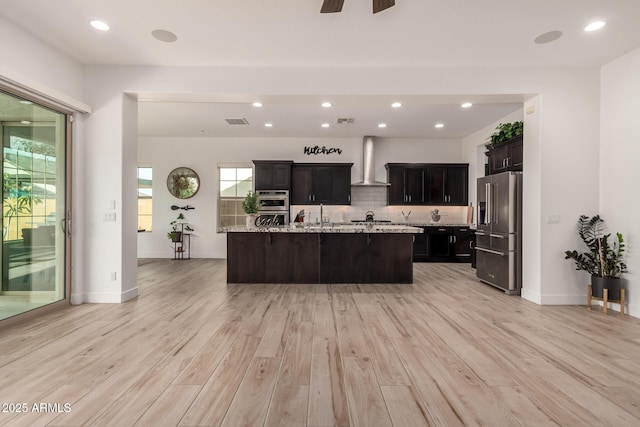2316 E Canary Dr, Gilbert, AZ 85297 - kitchen featuring appliances with stainless steel finishes, wall chimney exhaust hood, light wood-type flooring, backsplash, and recessed lighting