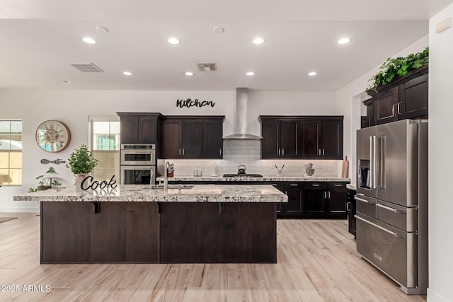 2316 E Canary Dr, Gilbert, AZ 85297 - kitchen with stainless steel appliances, wall chimney exhaust hood, a kitchen island with sink, tasteful backsplash, and recessed lighting