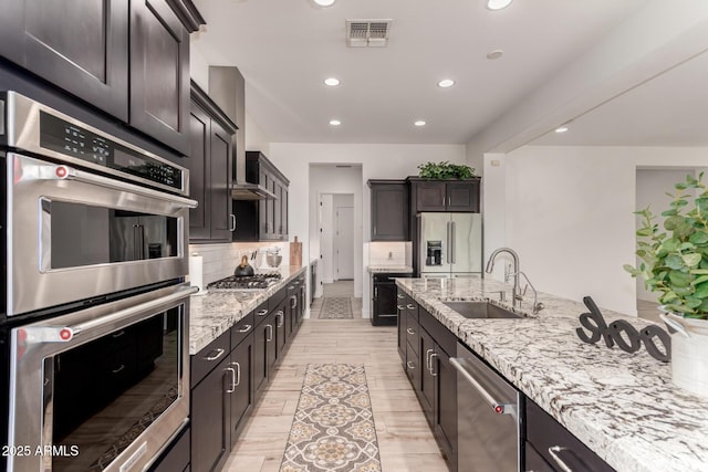 2316 E Canary Dr, Gilbert, AZ 85297 - kitchen featuring appliances with stainless steel finishes, a sink, recessed lighting, light stone countertops, and backsplash