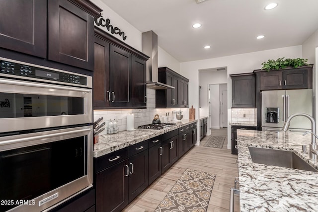 2316 E Canary Dr, Gilbert, AZ 85297 - kitchen featuring appliances with stainless steel finishes, a sink, wall chimney range hood, decorative backsplash, and recessed lighting