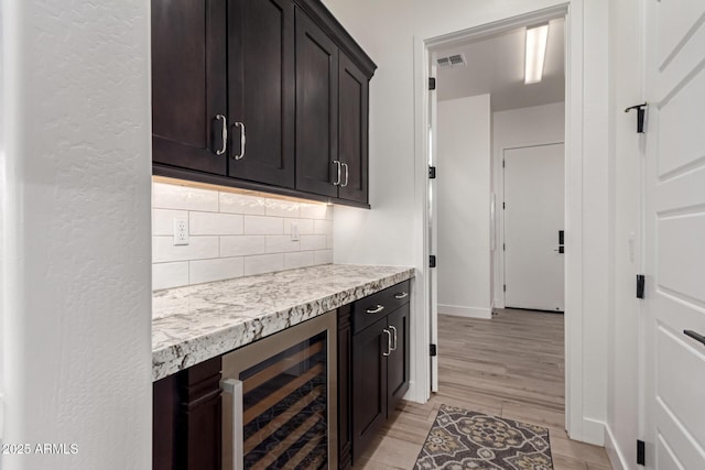2316 E Canary Dr, Gilbert, AZ 85297 - kitchen with beverage cooler, decorative backsplash, light countertops, light wood-type flooring, and dark brown cabinets