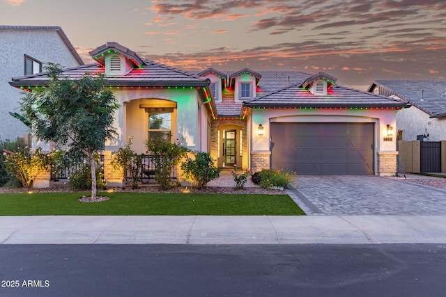 2316 E Canary Dr, Gilbert, AZ 85297 - view of front facade with decorative driveway, stucco siding, an attached garage, brick siding, and a tiled roof