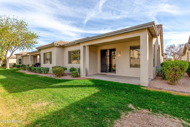 back of property with a yard and a patio area