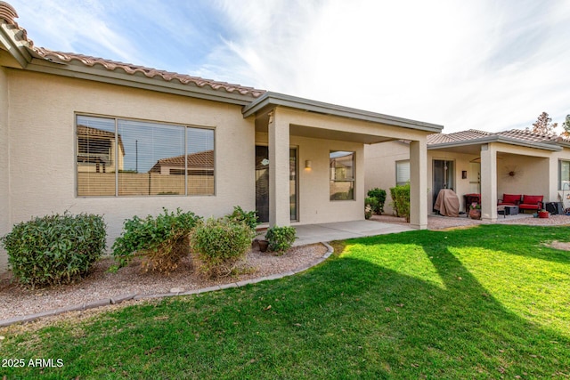 rear view of property featuring a patio area and a lawn