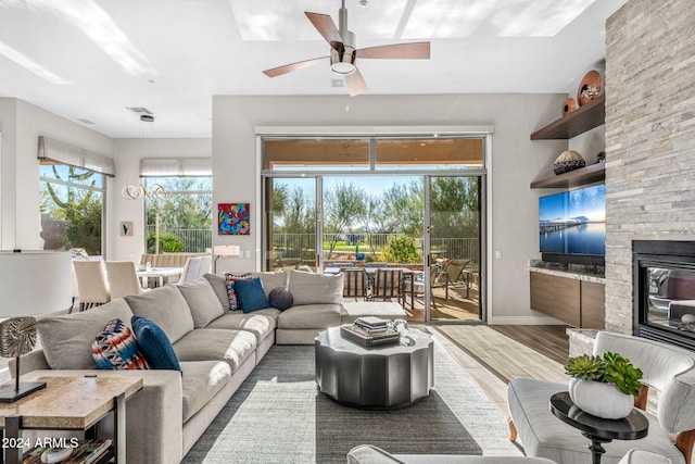 living room featuring ceiling fan, a healthy amount of sunlight, wood-type flooring, and built in shelves