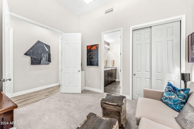 sitting room featuring light carpet and a high ceiling