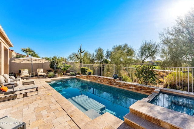 view of swimming pool featuring an in ground hot tub and a patio