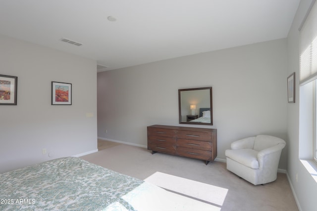 bedroom featuring light carpet and multiple windows