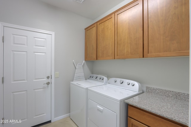 laundry room featuring washer and dryer and cabinets