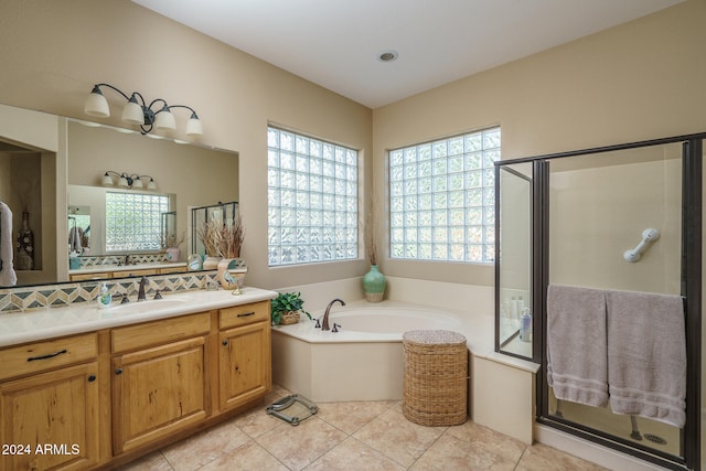 bathroom featuring shower with separate bathtub, vanity, and tile patterned flooring