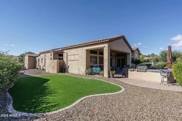 back of house with an outdoor kitchen and a patio