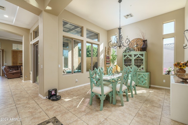 tiled dining room with a chandelier