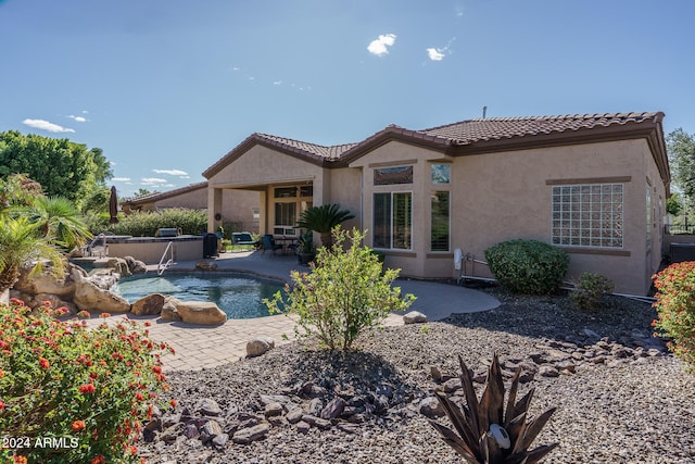 rear view of house featuring pool water feature, cooling unit, and a patio