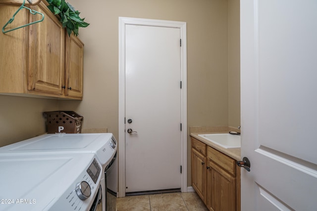 clothes washing area featuring cabinets, washer and clothes dryer, sink, and light tile patterned flooring