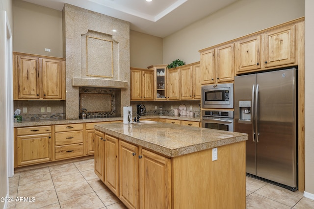 kitchen featuring an island with sink, light tile patterned floors, sink, and appliances with stainless steel finishes