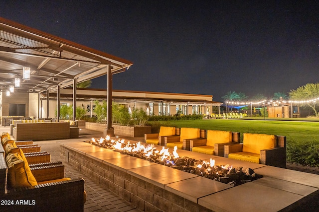 patio at twilight featuring an outdoor living space with a fire pit