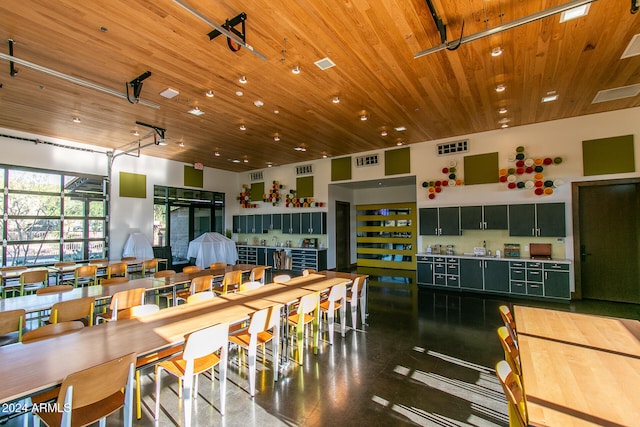 kitchen with wood ceiling, green cabinetry, and a towering ceiling