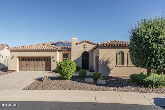 mediterranean / spanish-style home with a garage and solar panels