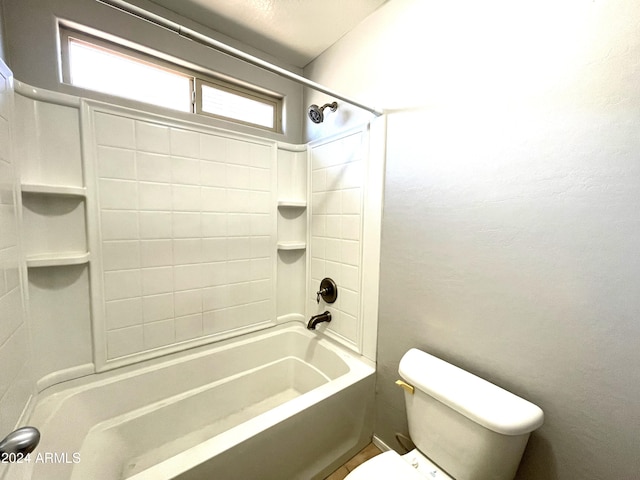 bathroom with toilet and tiled shower / bath combo